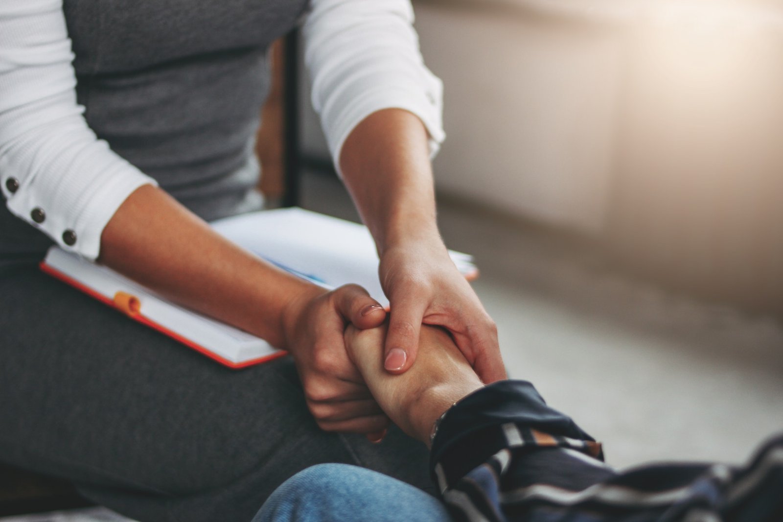 Woman support and help concept. Women hold each other's hands sitting in loft office