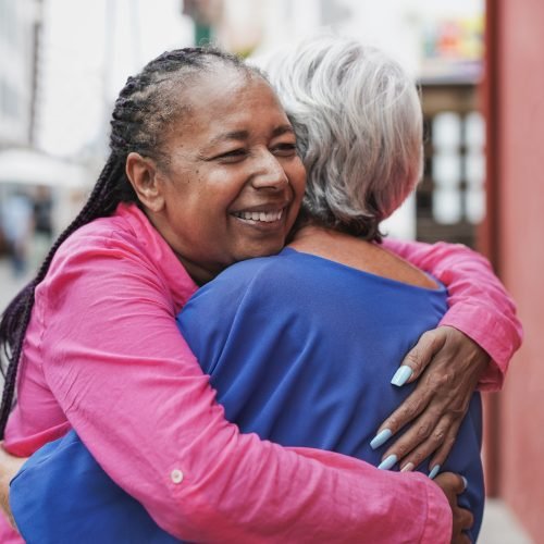 Elderly multiracial women hugging each other - Friendship, love and senior people concept