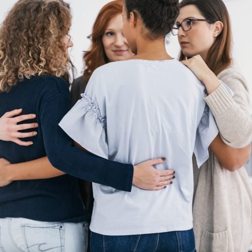 Women with issues supporting together during group therapy